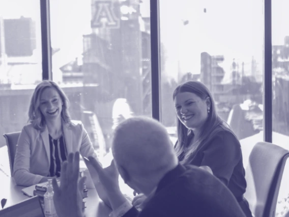 The A&R team talking around a table, with the Stadium in the background